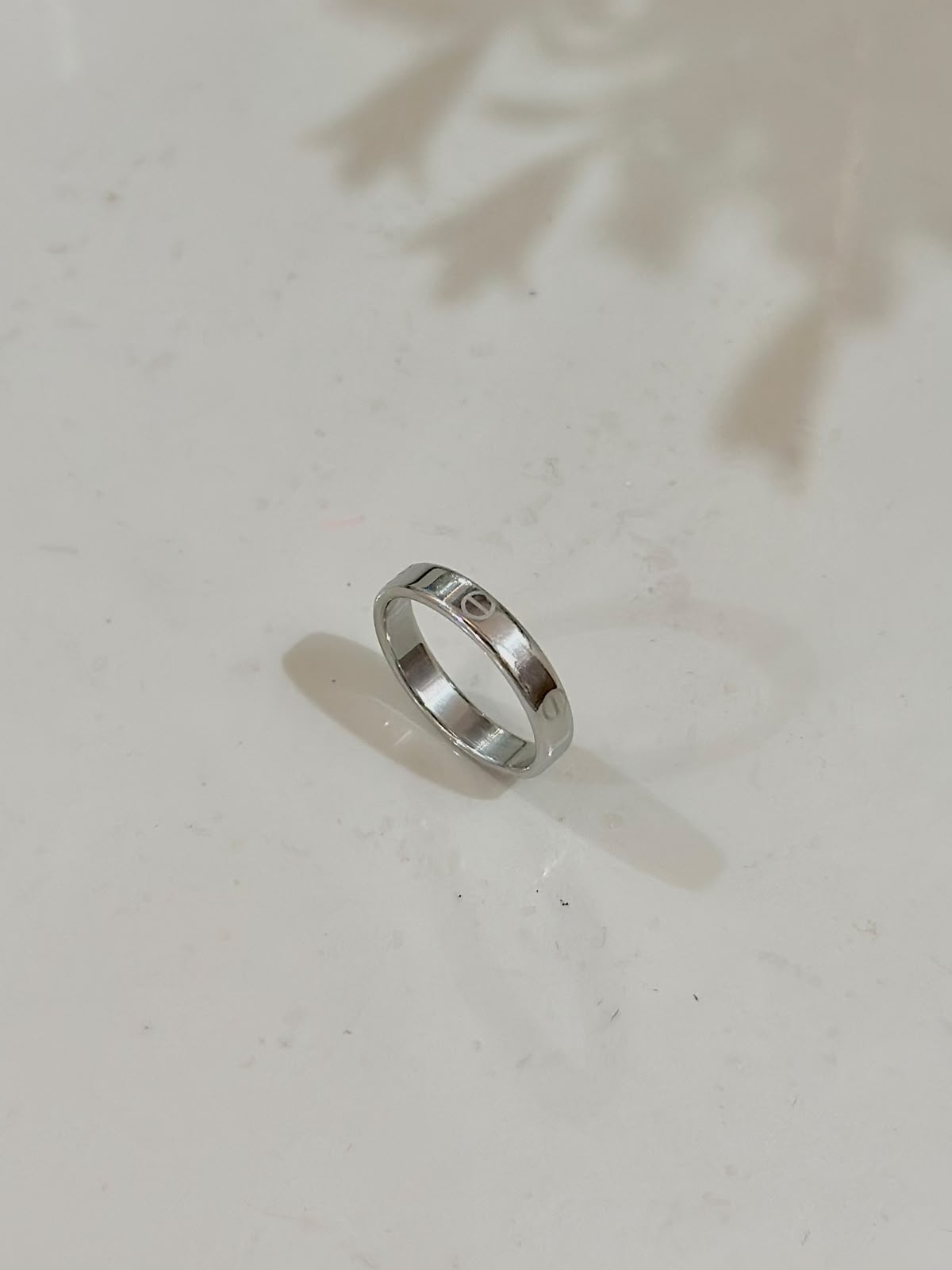 Silver Cartier Style Love Ring by Bloslily, close-up of the elegant jewelry piece with smooth, polished surface and engraved design.