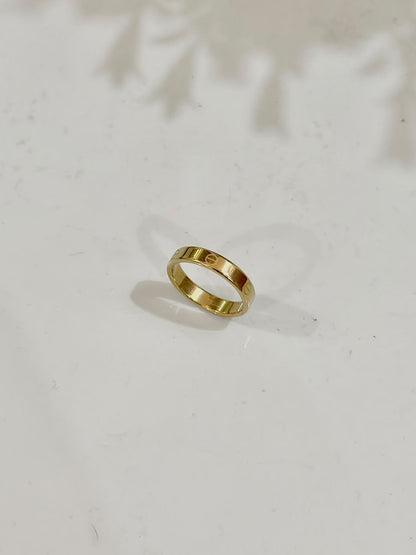 Golden Cartier Style Love Ring by Bloslily, showcasing a sleek band with engraved love motifs on shiny jewelry surface.