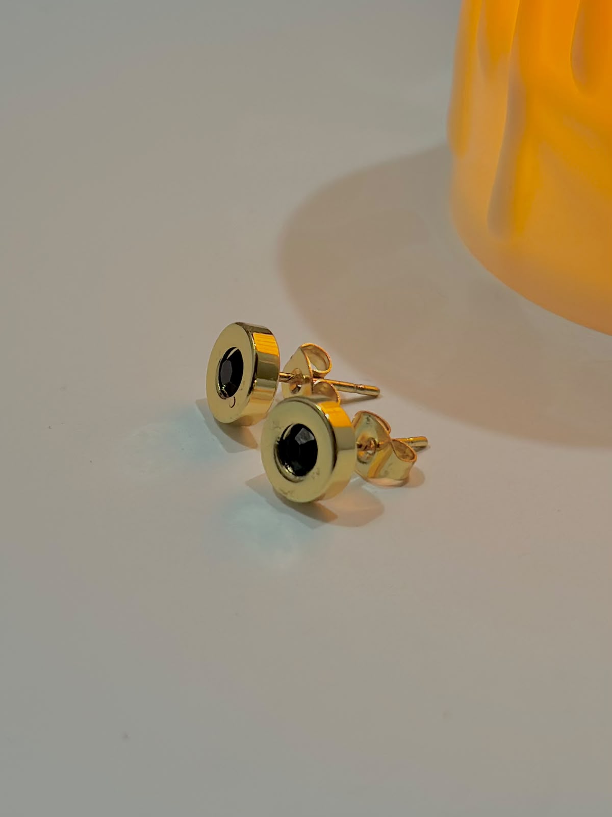 Black stone stud earrings from Bloslily jewelry, close-up view showing round black gemstone set in silver-toned metal.