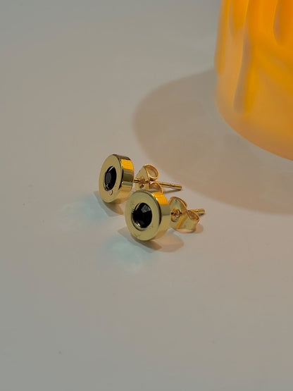 Black stone stud earrings from Bloslily jewelry, close-up view showing round black gemstone set in silver-toned metal.