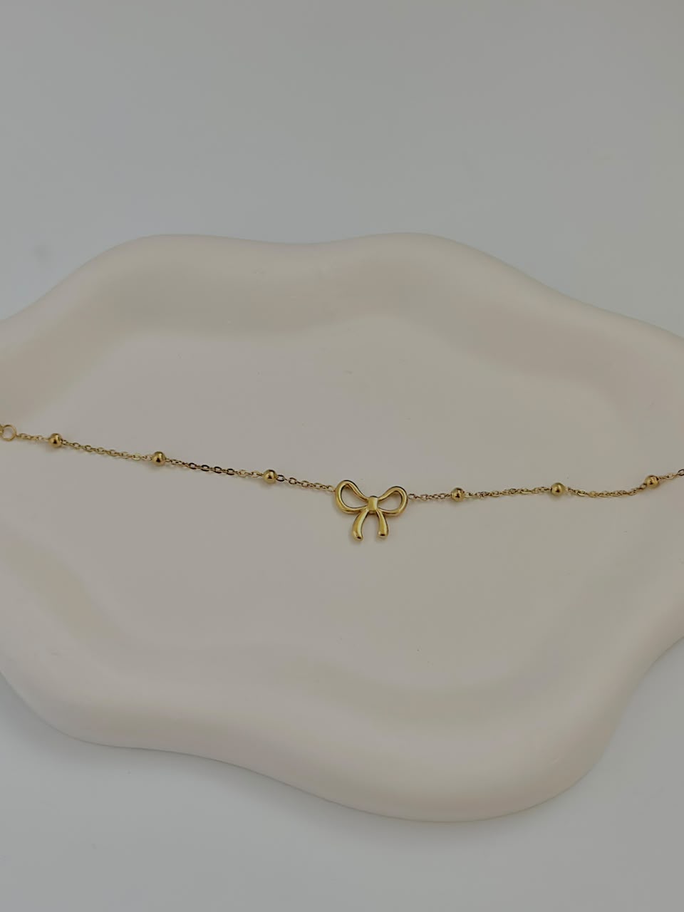 Bloslily dainty bow charm bracelet featuring a delicate bow pendant on a fine jewelry chain.