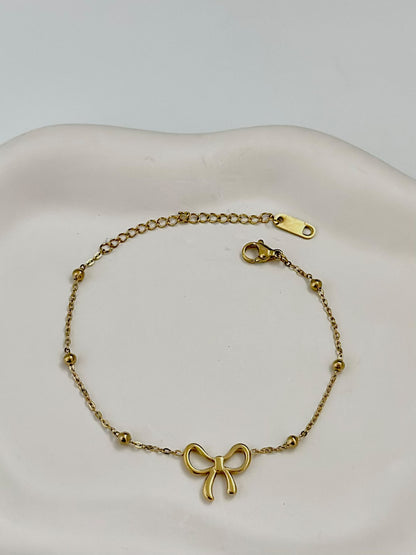 Silver dainty bow charm bracelet by Bloslily featuring a delicate bow design on a sleek jewelry bracelet.
