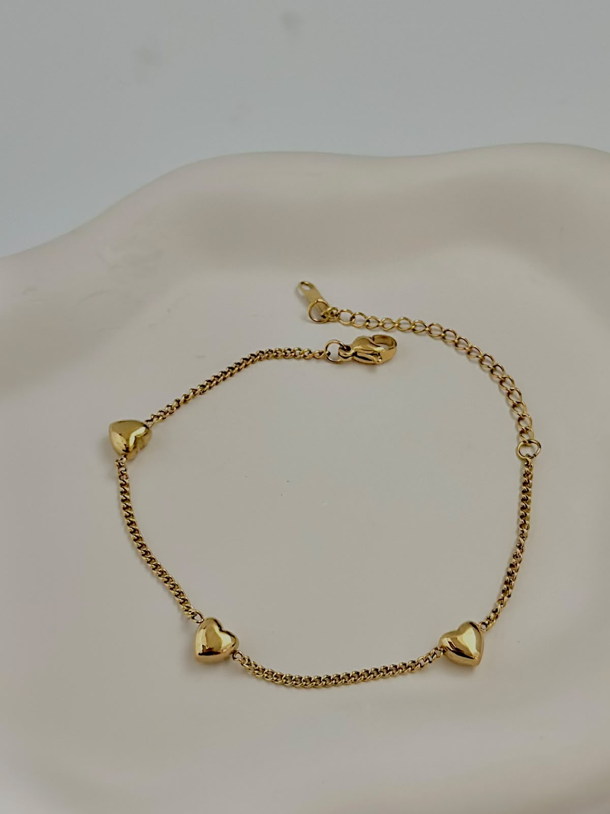 Delicate Bloslily jewelry bracelet featuring multiple small heart charms on a fine chain.