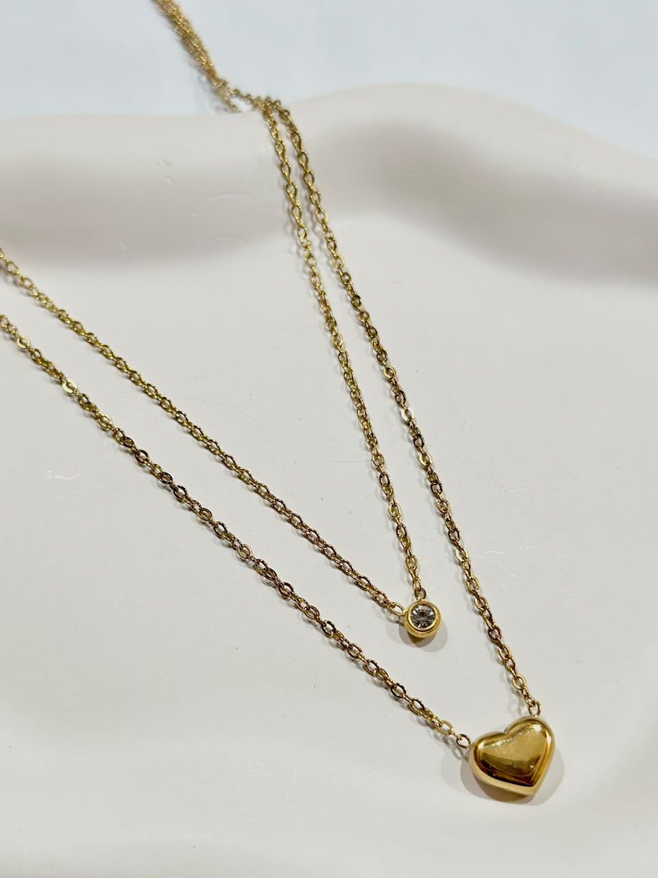 Bloslily double layer jewelry necklace featuring a heart pendant with a small dot and a solitaire charm.