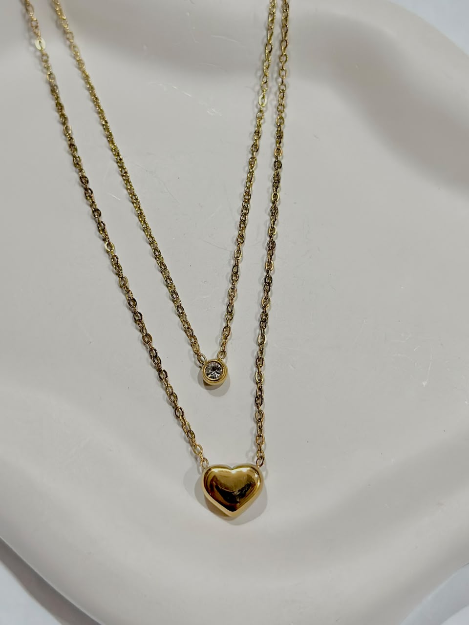 Silver double layer jewelry necklace featuring a heart pendant with a small dot and a solitaire charm from Bloslily.