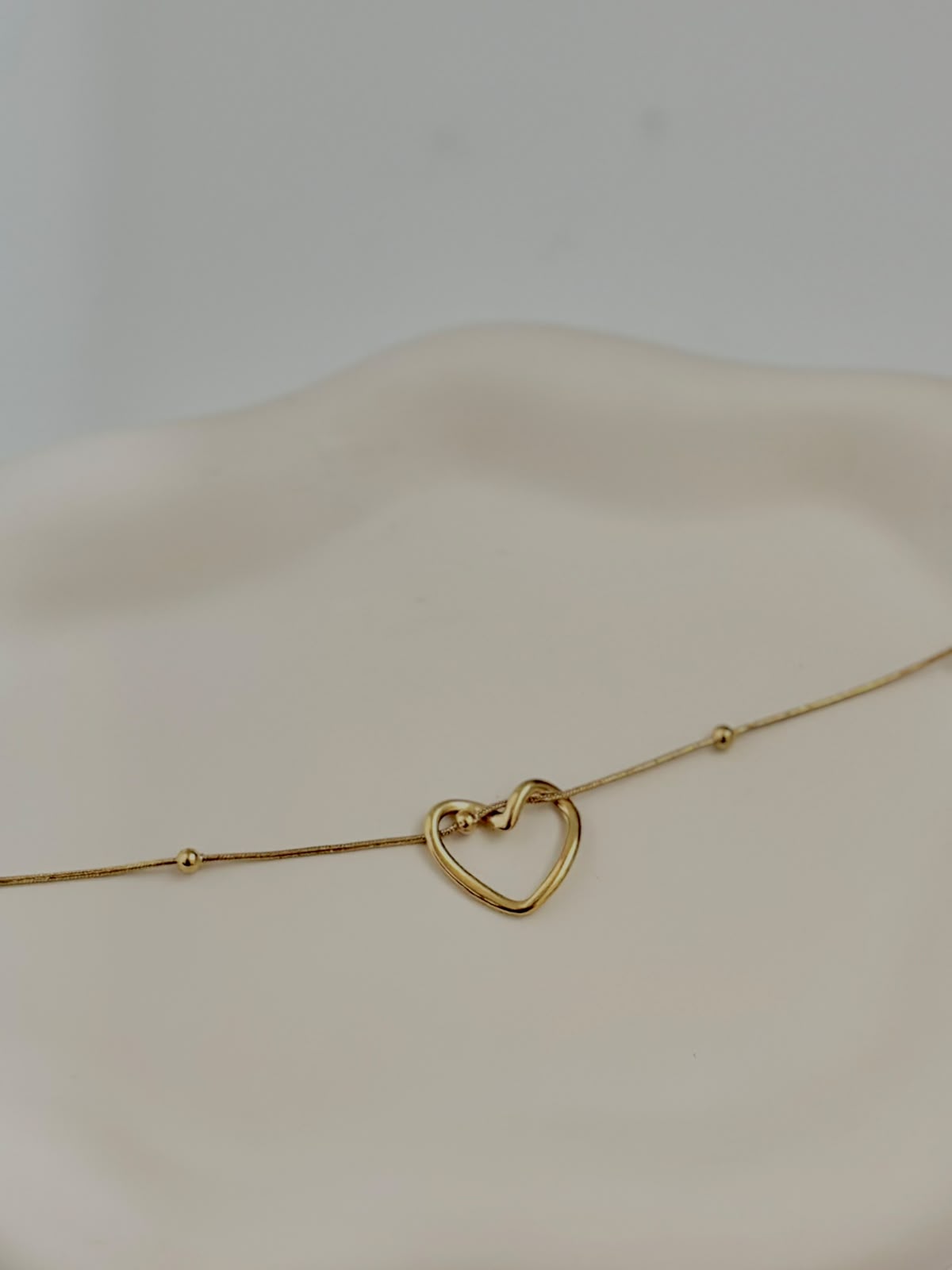 Silver intertwined heart bracelet from Bloslily featuring a delicate jewelry design with interconnected heart shapes.